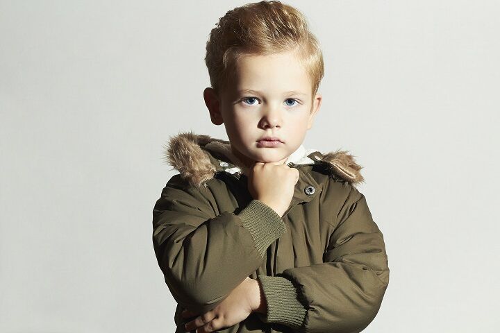 Jongen met blond haar die een groene winterjas draagt