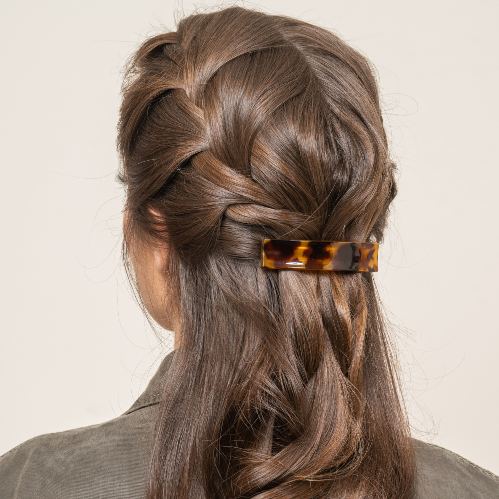 Lang krullend brunette haar getoond van achteren met Franse vlechten half omhoog kapsel en haar baret