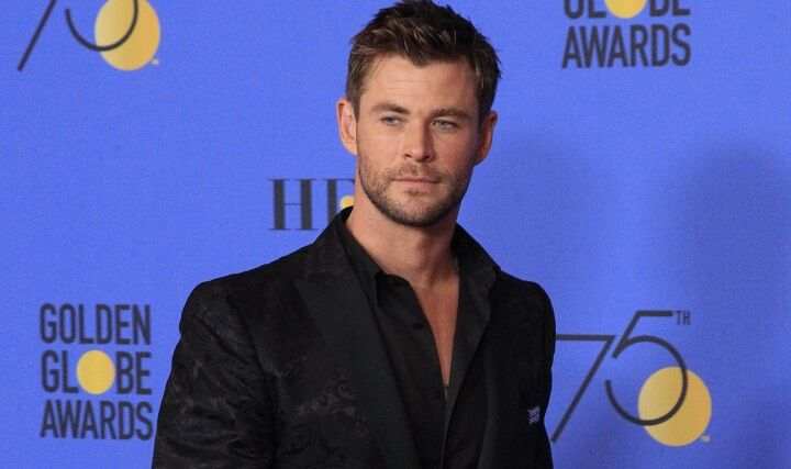 Chris Hemsworth in een zwart pak met korte stoppelbaard
