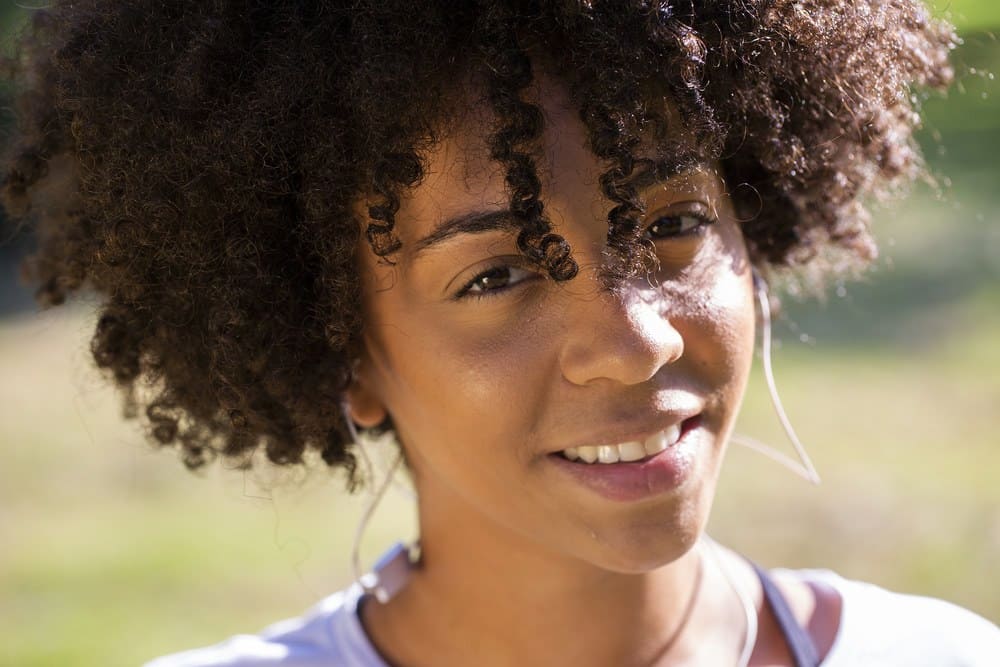 Close-up portret van een aantrekkelijke Braziliaanse vrouw die buiten glimlacht.