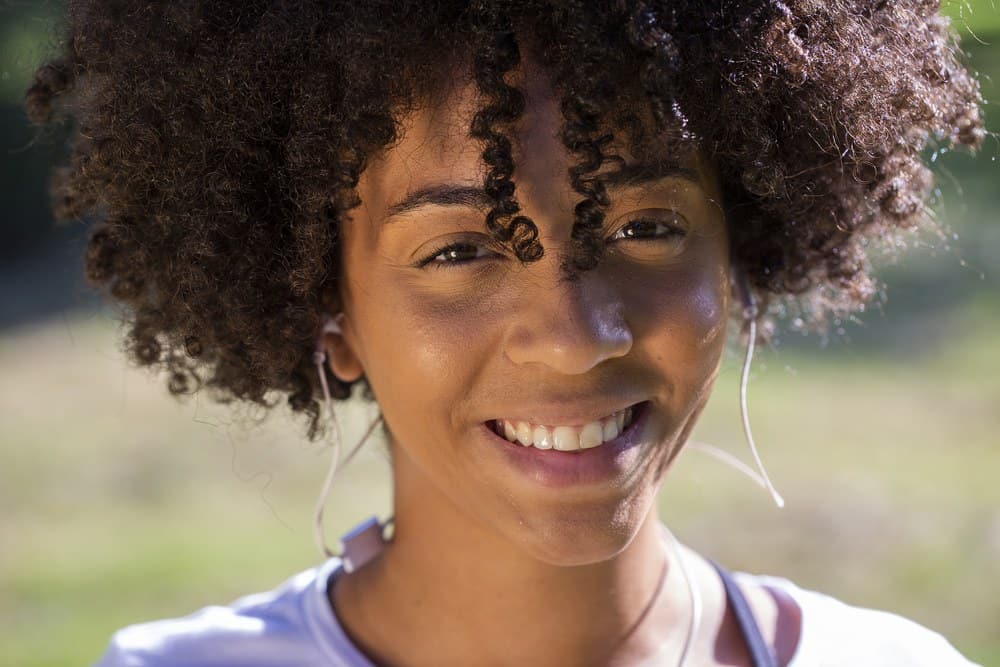 Close-up portret van een aantrekkelijke gemengde Afrikaanse Braziliaanse vrouw die buiten glimlacht.