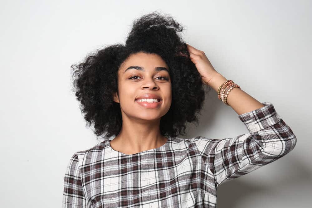 Afro-Amerikaanse vrouwen glimlachen terwijl ze een rood-wit-zwarte jurk dragen.