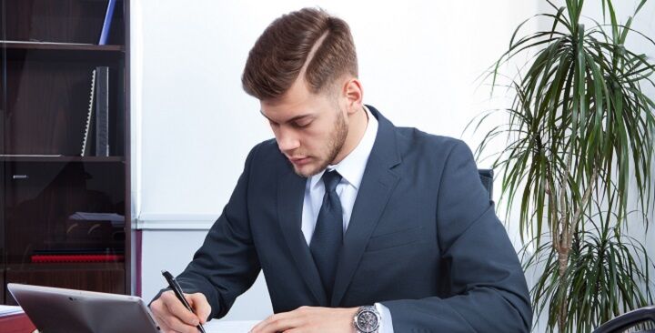 Professional met een undercut kapsel en haarlijn in een pak aan het werk