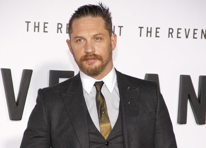 Tom Hardy in een pak met korte baard en Greaser kapsel