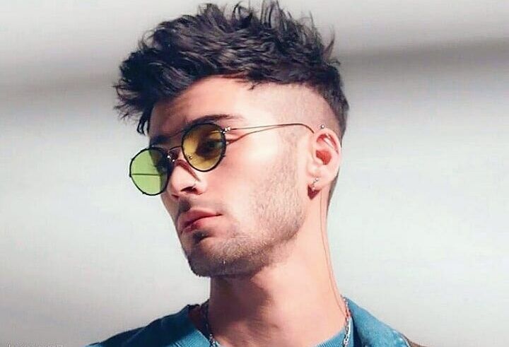 Zayn Malik met een rommelig kaal kapsel en een zonnebril.