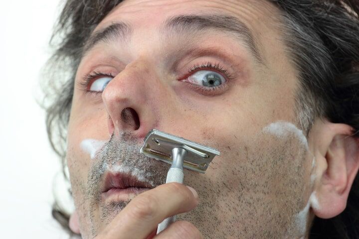 Scared Man Holding a Razor and Shaving