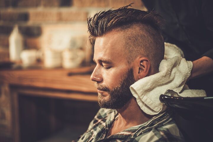 Hairstylist die het haar en de baard van de man wast