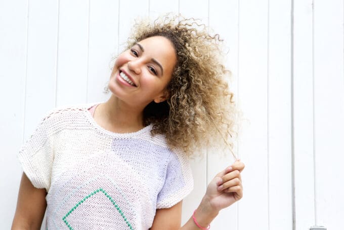 Leuk Afro-Amerikaans meisje bruin en zwart krullend haar gestyled met gemengde haarverf