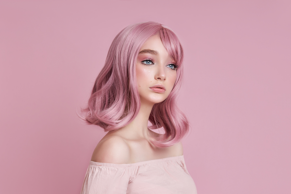 Light Victorian Rose Pink haar op een vrouw in een roze kamer met een stoïcijnse uitdrukking op haar gezicht