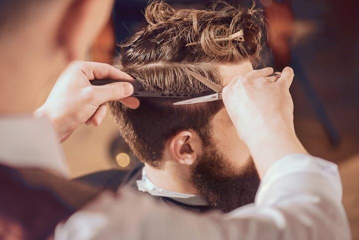 Professionele kapper trimmen man haar met schaar