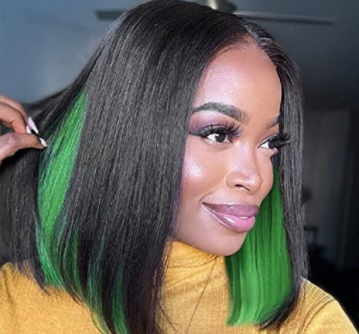 Zwart meisje met een groene kiekeboe haar