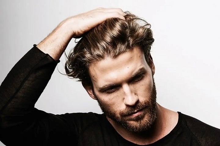 Bearded Man With a Bro Flow Hairstyle Touching His Hair