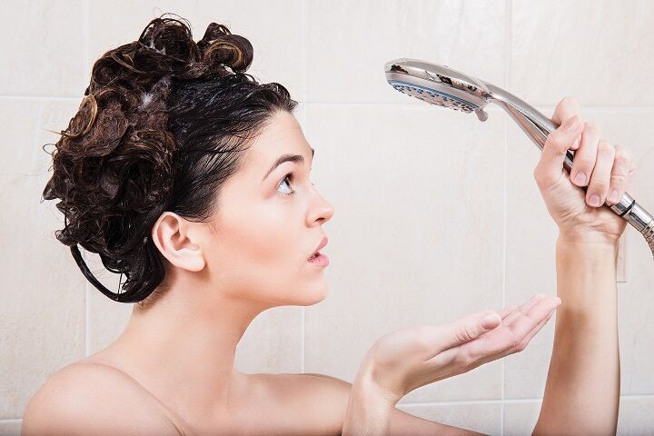 Meisje onder de douche bereidt zich voor om haar haar te wassen