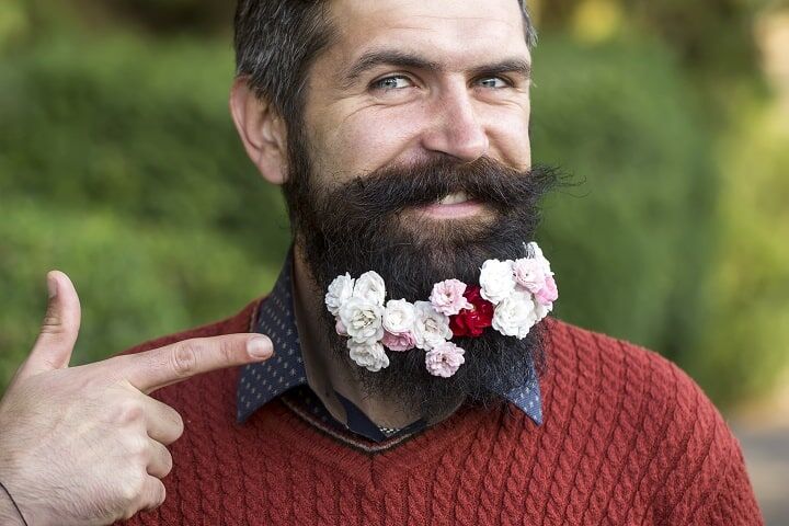 Man met bloemen op baard